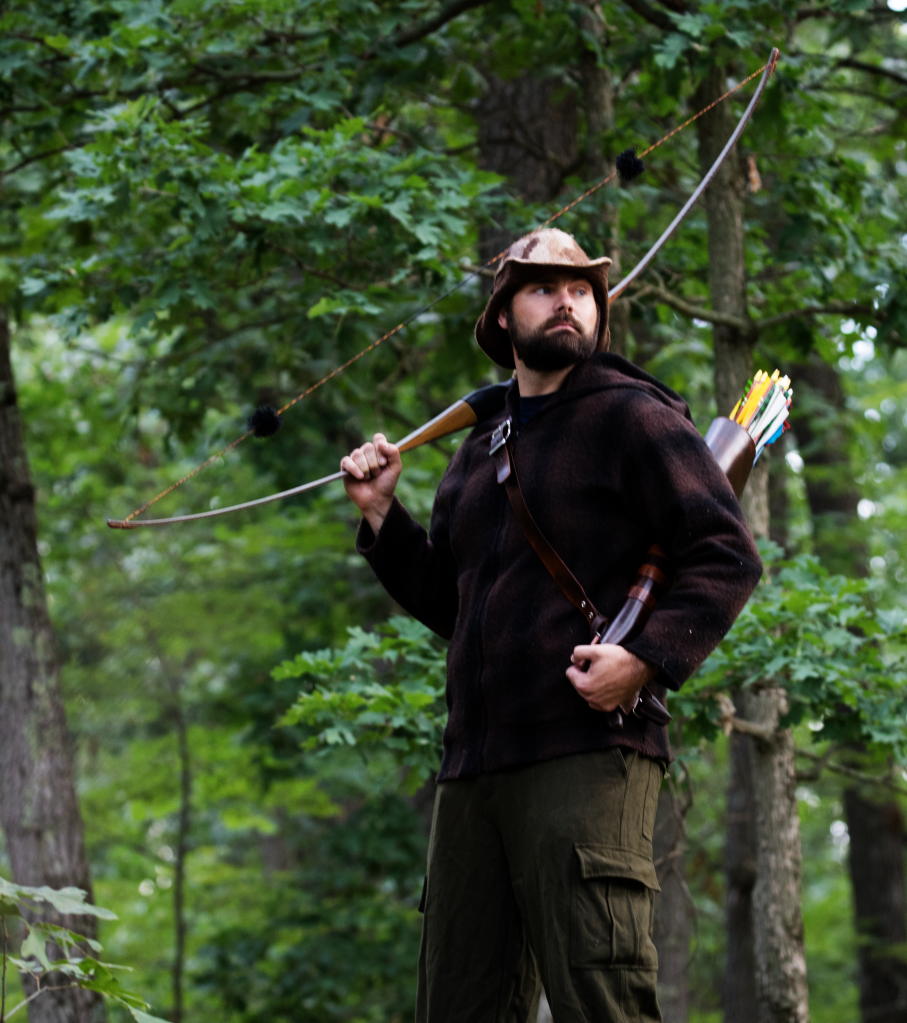 Nick in the woods with his longbow.